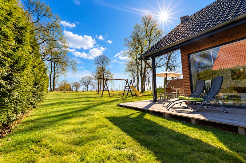 Garten mit Liegestühlen, Schaukel und Rutsche