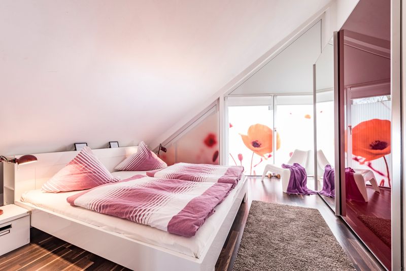Schlafzimmer mit Doppelbett unter der Dachschräge